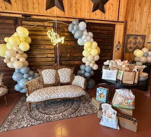 Pastel balloon arch and gift table styled for a baby shower at On Collin's Pond