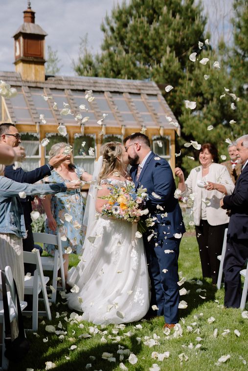 Guests showering the newlyweds with petals outside the garden chapel at On Collin's Pond