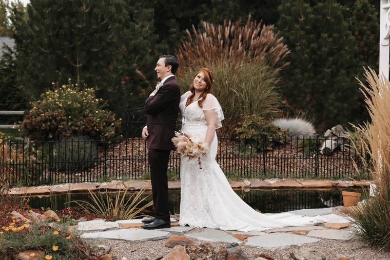 Bride and groom beside the gazebo with orange poppies in bloom at On Collin's Pond
