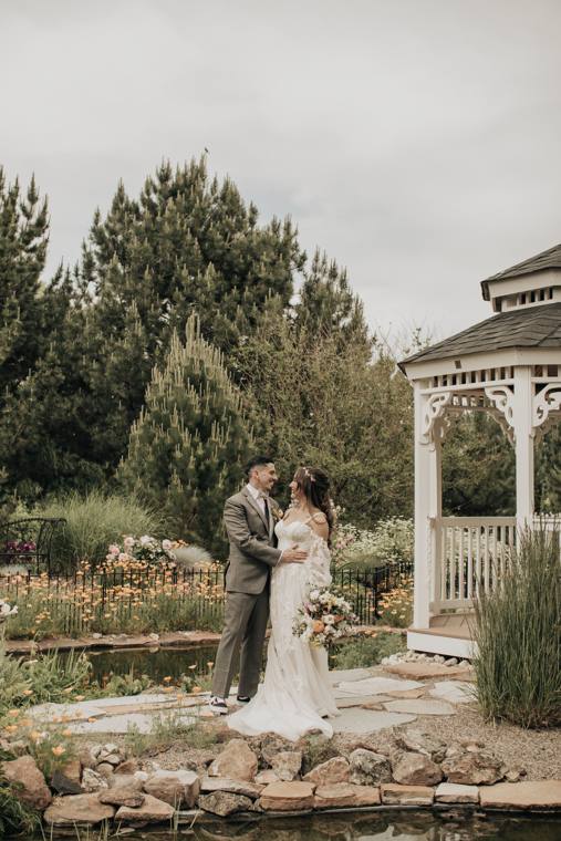 Bride and groom by the gazebo and pond in spring at On Collin's Pond
