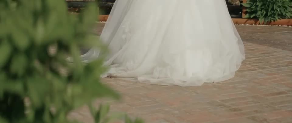Bride's gown trailing along the brick path during a garden wedding at On Collin's Pond