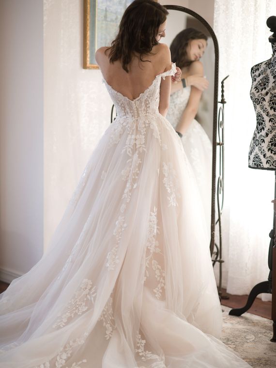 Back of the bride's gown beside the antique dress form in the bride's room at On Collin's Pond
