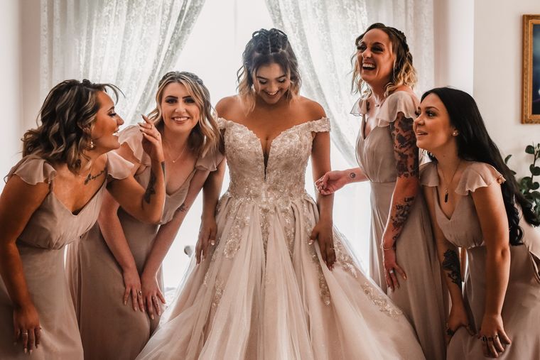 Bride laughing with her bridesmaids in the bride's room at On Collin's Pond