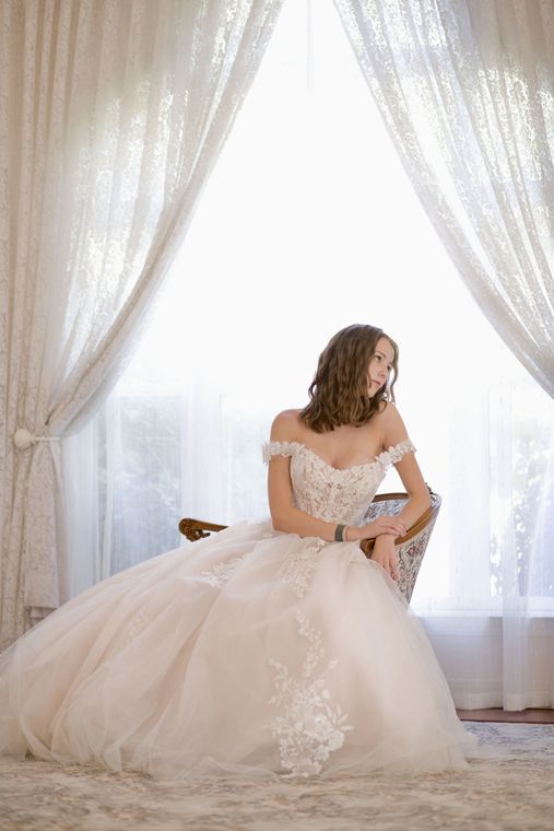Bride seated in soft window light in the bride's room at On Collin's Pond