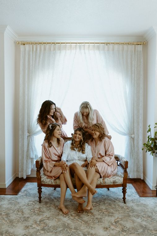 Bridesmaids helping the bride get ready in the bride's room at On Collin's Pond