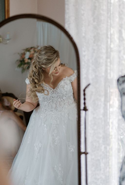 Bride at the mirror with flowers in her hair at On Collin's Pond