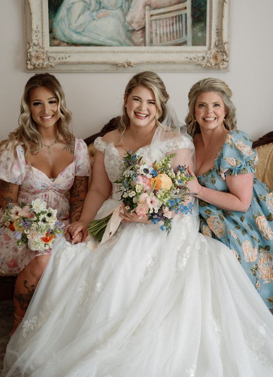 Bride with her mother and bridesmaid holding bouquets at On Collin's Pond