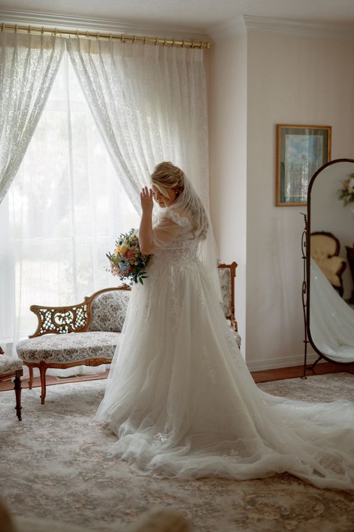Bride adjusting her gown in the bride's room at On Collin's Pond