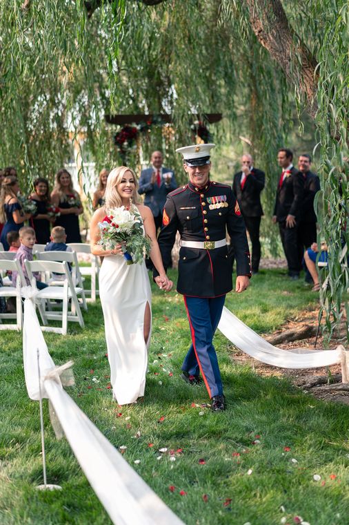 Bride and Marine groom walking back up the aisle after their ceremony at On Collin's Pond