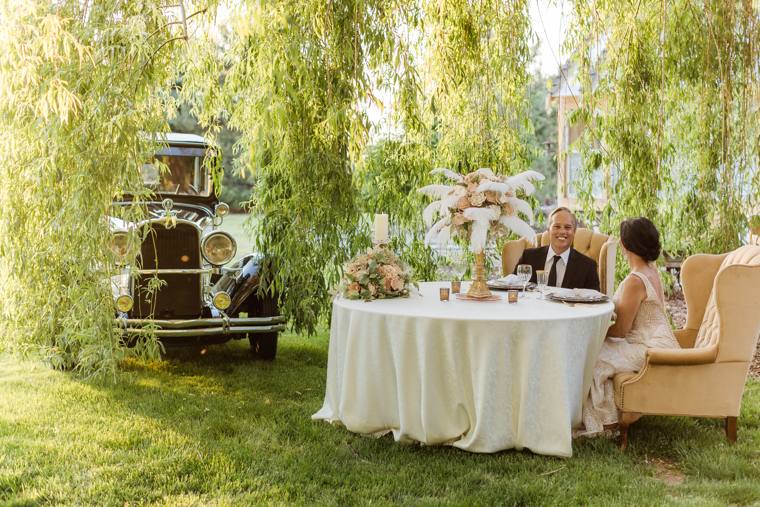 Sweetheart table set beneath the willow beside the classic car at On Collin's Pond