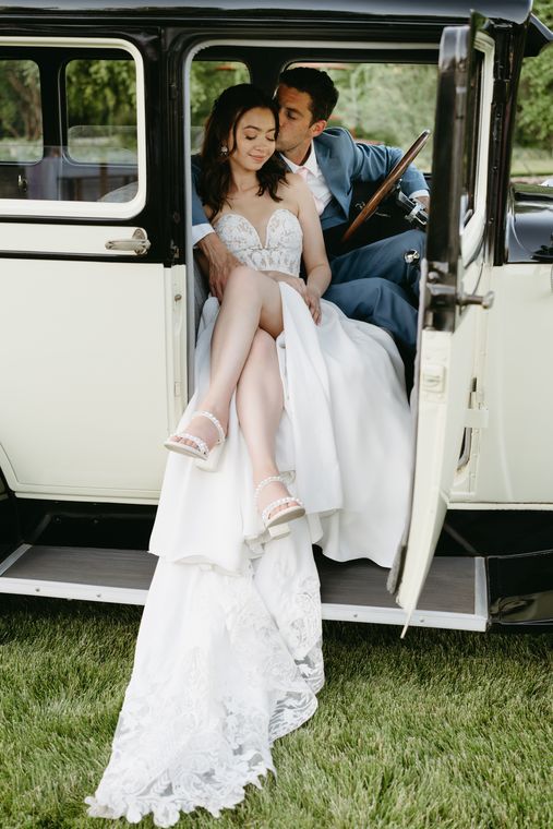 Bride and groom seated in the vintage car at On Collin's Pond