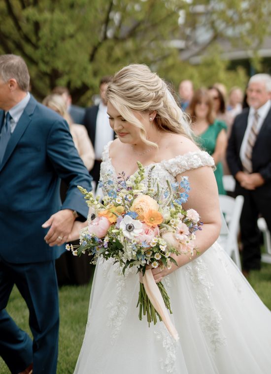 Bride carrying her bouquet down the aisle at On Collin's Pond