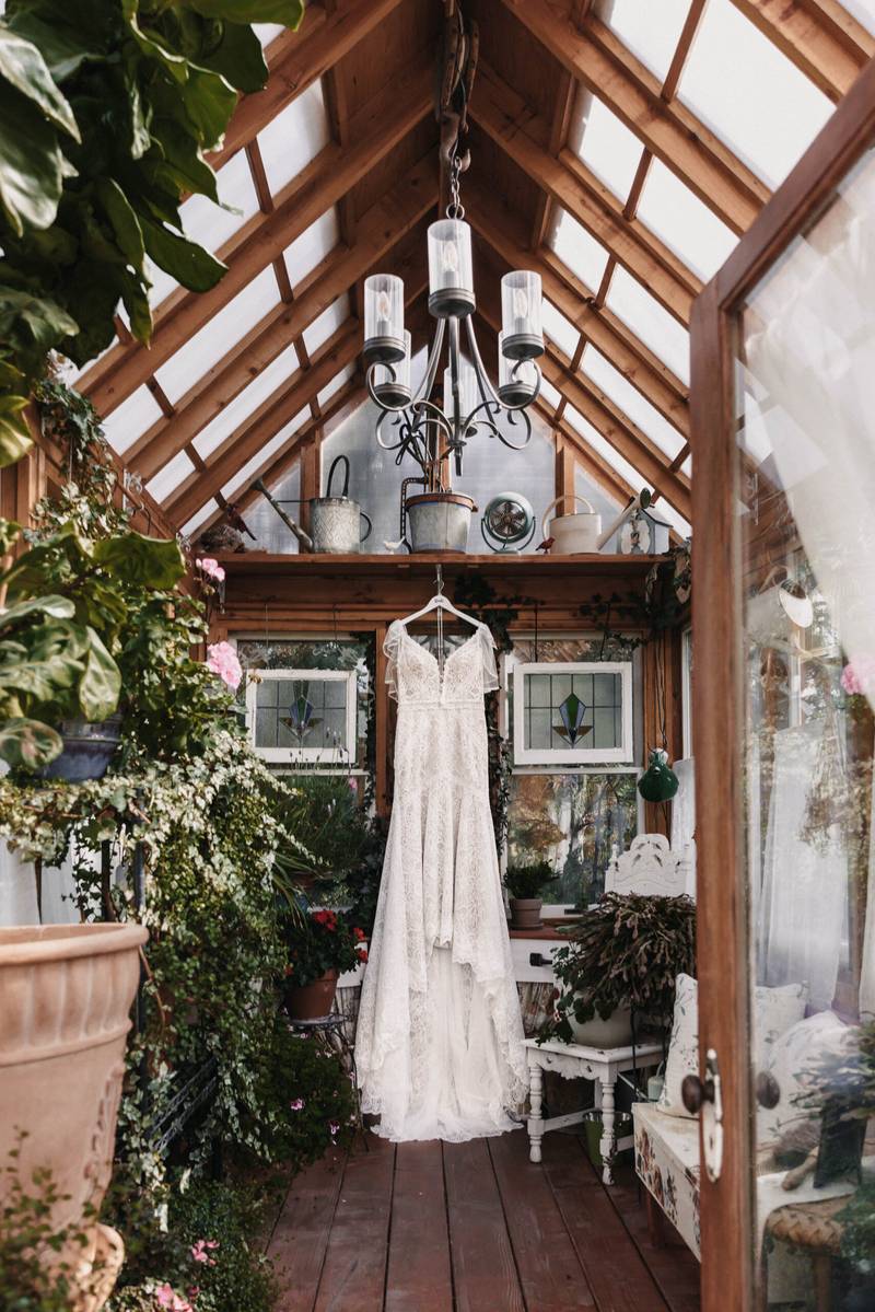 Vintage chandelier and wedding gown inside the old-world greenhouse at On Collin's Pond, Middleton, Idaho