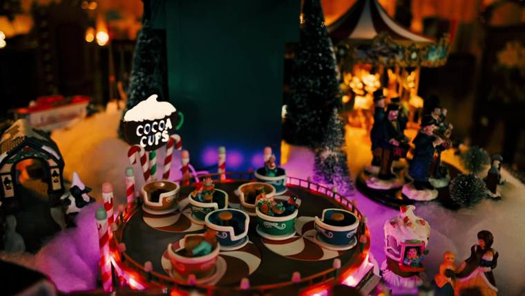 A lit miniature Christmas village inside Santa's Lodge and Workshop at On Collin's Pond