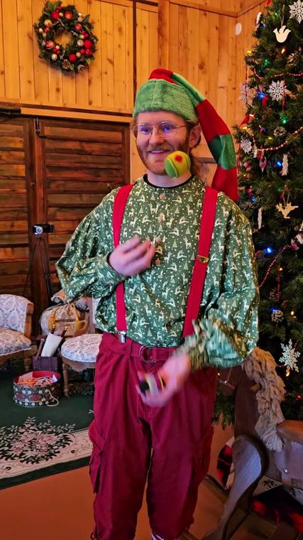 One of Santa's elves welcoming visitors inside the decorated lodge at On Collin's Pond
