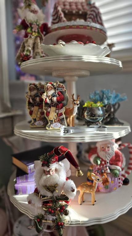 Tiered dessert stands with vintage Santa figures and a peppermint gingerbread house