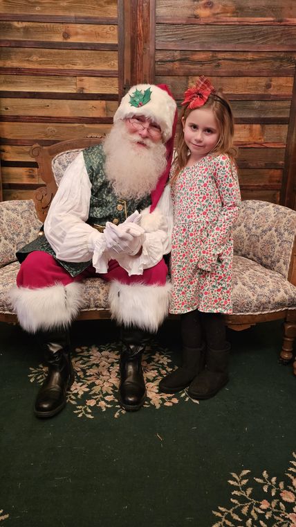 Santa Phil with a young visitor on the settee in the lodge at On Collin's Pond