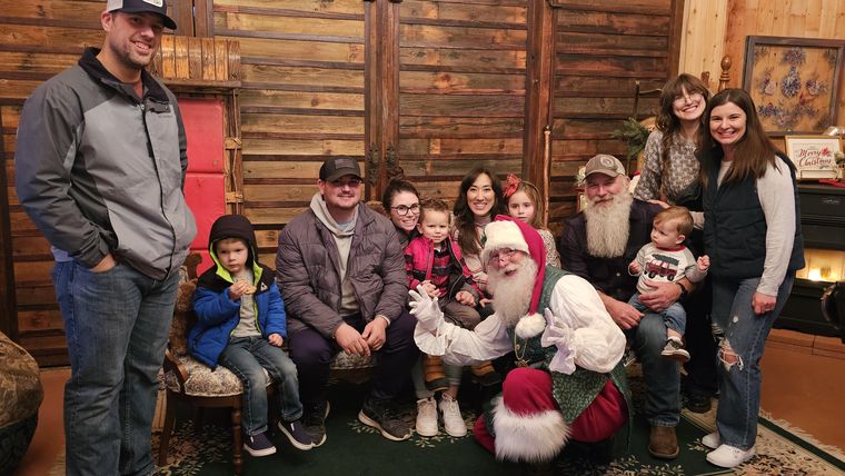 A large family gathered with Santa Phil in the lodge at On Collin's Pond