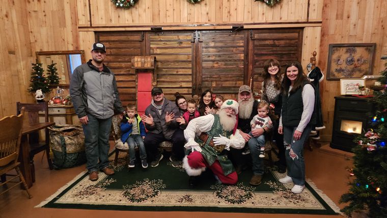 Families posing together with Santa Phil in the lodge at On Collin's Pond