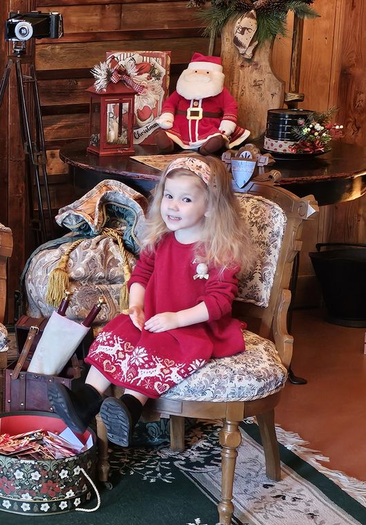 A child with her gifts in the lodge at Santa's Workshop on Collin's Pond