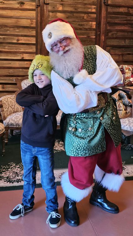 A boy hugging Santa Phil in the lodge at On Collin's Pond
