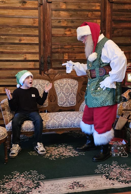 A child meeting Santa Phil in the lodge at On Collin's Pond
