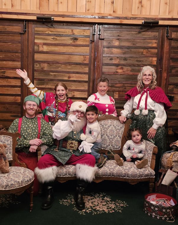 A family gathered on the settee with Santa Phil and the elves at On Collin's Pond