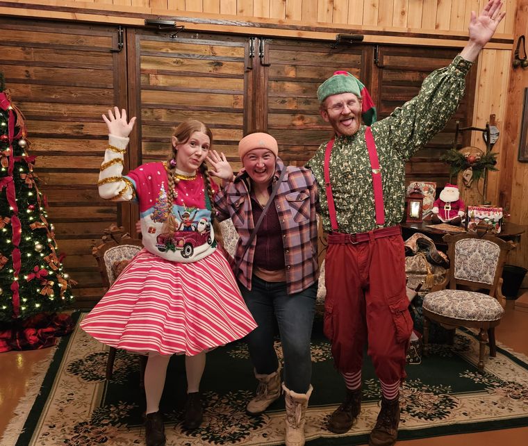Elves celebrating with a guest in the lodge at On Collin's Pond