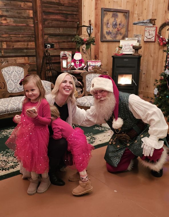 A family meeting Santa Phil and an elf in the lodge at On Collin's Pond