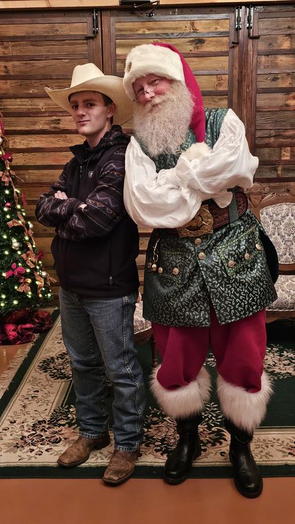 Santa Phil with a young visitor in a cowboy hat at On Collin's Pond
