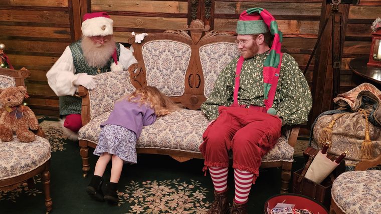Santa Phil and an elf waiting to welcome guests in the lodge at On Collin's Pond