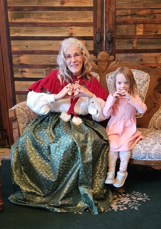 Mrs. Claus with a little girl in the lodge at On Collin's Pond