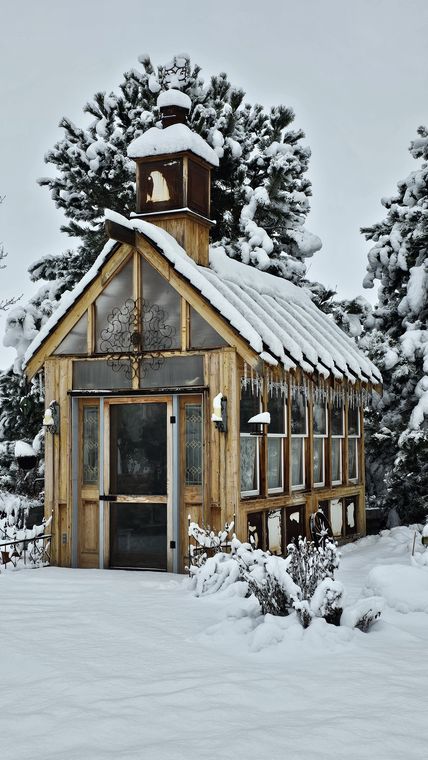 The greenhouse and winter garden blanketed in snow at On Collin's Pond, Middleton, Idaho