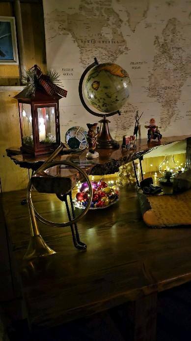 Inside Santa's workshop — globe, lantern and maps on the work desk