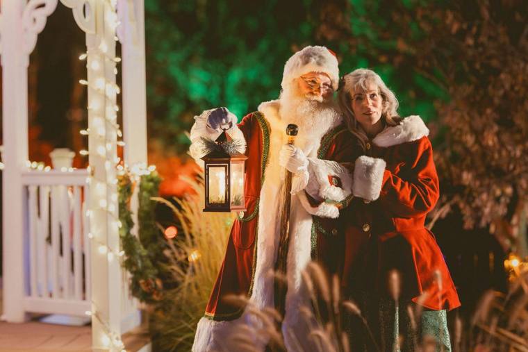 Santa and Mrs. Claus beside the lit gazebo with a lantern at On Collin's Pond, photographed by Jerry Moyer Photography