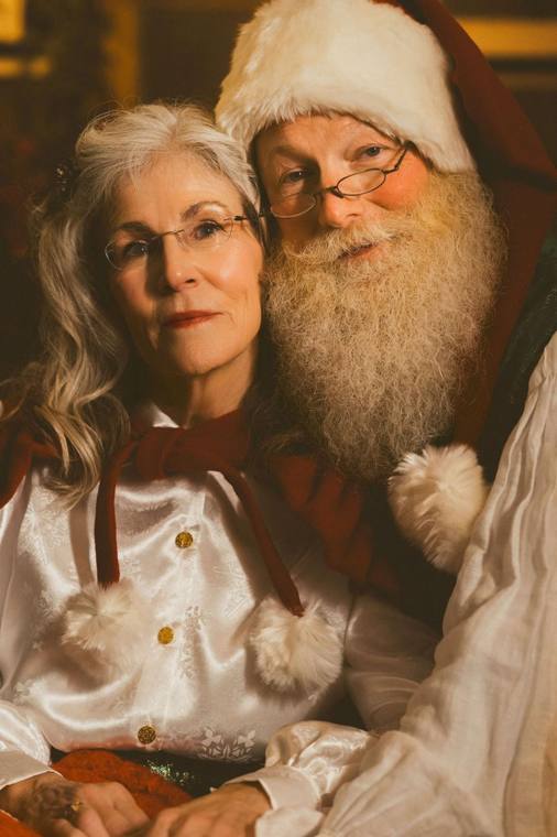 Portrait of Santa Phil and Mrs. Claus by the fire, photographed by Jerry Moyer Photography