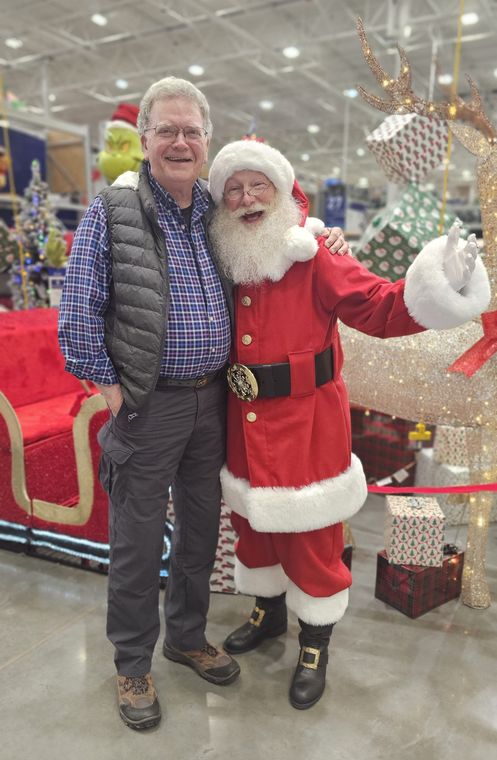 Santa Phil with a visitor beside the sleigh at an off-site Christmas event