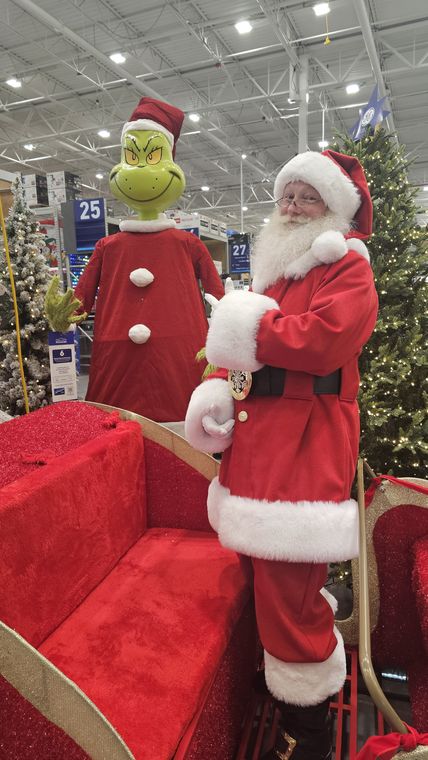 Santa Phil beside the sleigh among the Christmas trees at an off-site event