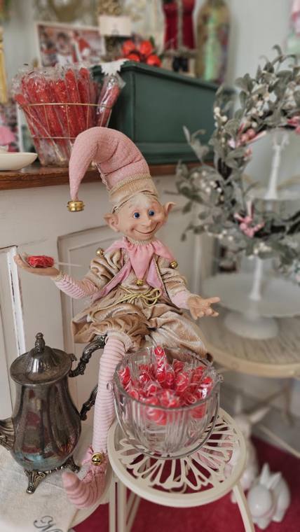 A pink velvet elf perched beside a bowl of candy in the Sweet Shoppe