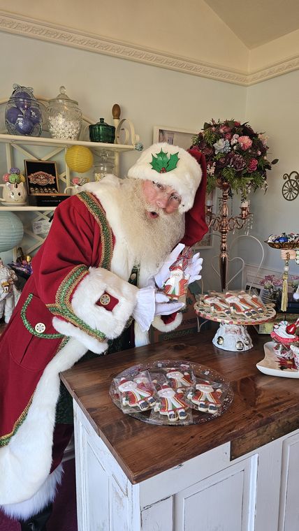 Santa Phil at the counter of Chelsea's Sweet Shoppe with decorated Christmas cookies