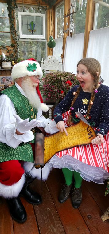 An elf and a guest in the greenhouse at Santa's Workshop on Collin's Pond
