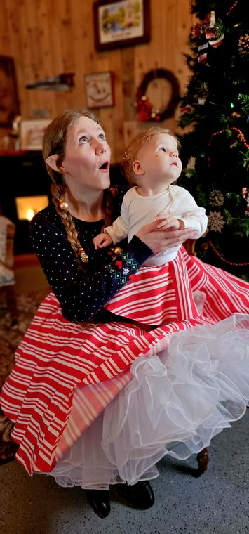 An elf holding a baby in Santa's Lodge and Workshop at On Collin's Pond