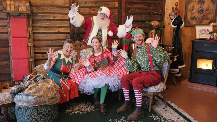 Santa Phil and his elves on the settee in the lodge at On Collin's Pond